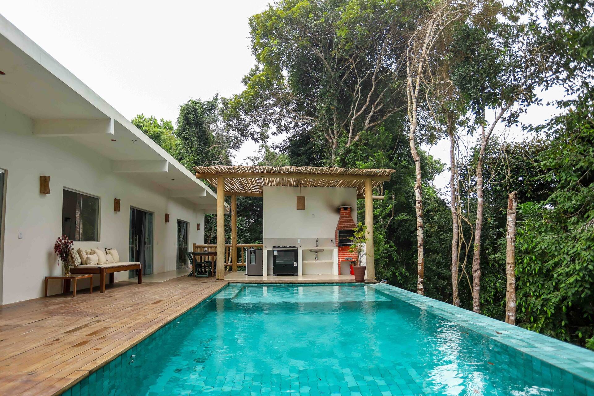Casa Elbacha, em Trancoso: piscina, deck e área gourmet cercados pela mata nativa